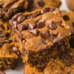 Brown butter pumpkin chocolate chip bars topped with warm chocolate chips