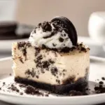 Delicious slice of creamy Oreo cheesecake garnished with Oreo cookies.
