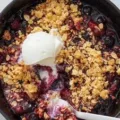 Stovetop berry crisp dessert topped with oats and fresh berries.