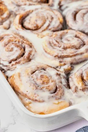 Delicious TikTok cinnamon rolls fresh out of the oven, topped with creamy icing.